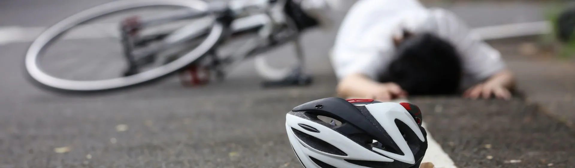 Bicyclist in road after being struck by a vehicle
